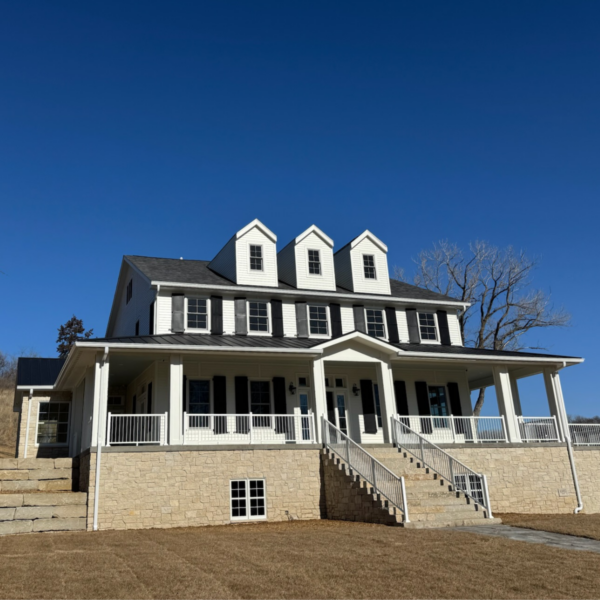 Modern farmhouse exterior with stone foundation and dormer windows