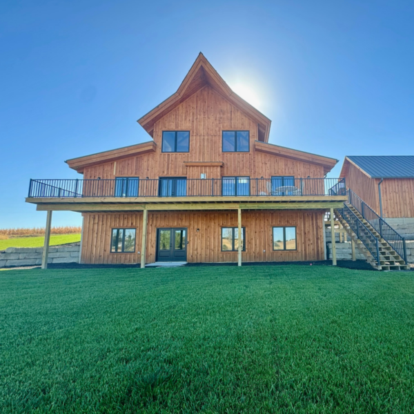 Stunning timber-frame home with an expansive deck and large windows.