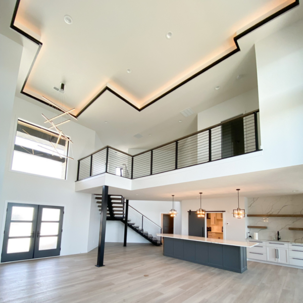 Modern two-story living space with recessed ceiling lighting and an open floor plan.