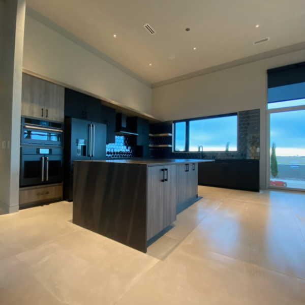 Contemporary kitchen with dark cabinetry, a large island, and built-in appliances.