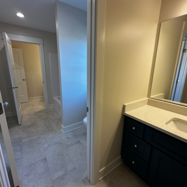 Elegant bathroom featuring a dual vanity, quartz countertops, and soft lighting.