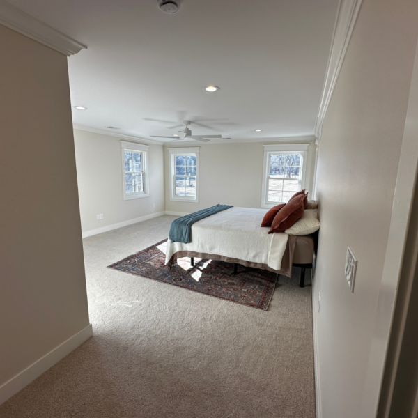 Spacious master bedroom with large windows, plush carpeting, and a neutral color scheme.