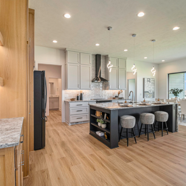 A spacious open-concept kitchen with a large island, modern lighting fixtures, and high-end appliances.