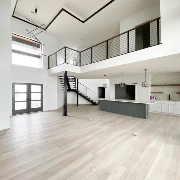 Two-story great room with an open-concept design, floating staircase, and modern kitchen island.