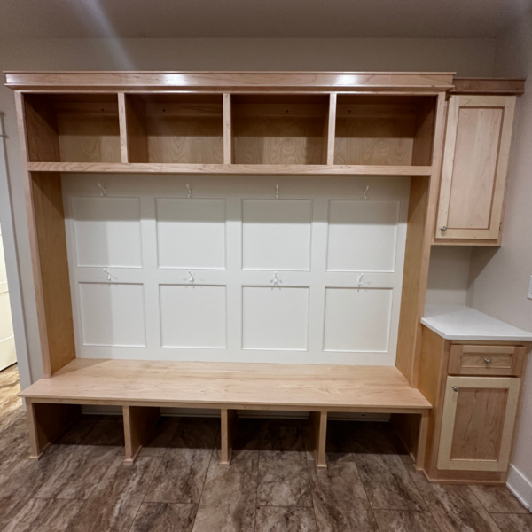 Custom-built wooden mudroom bench with storage and coat hooks