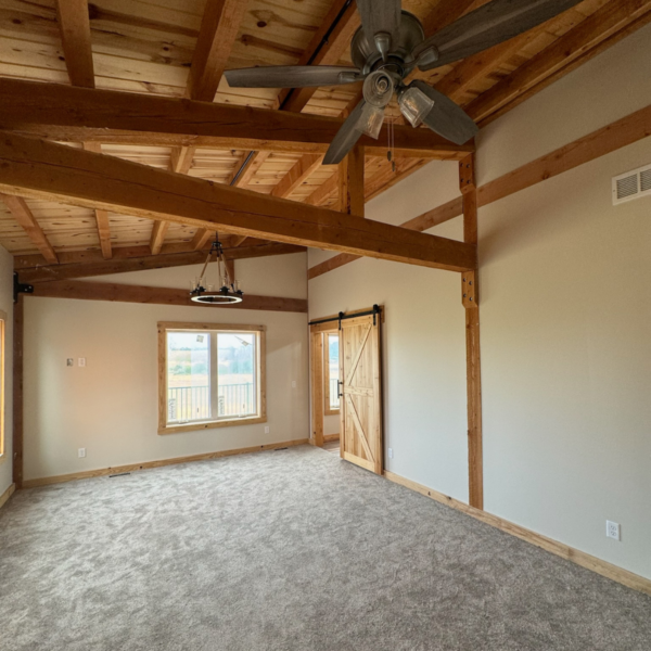 Interior of a timber home featuring exposed wooden beams and high ceilings.
