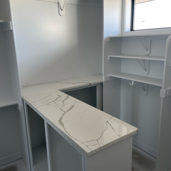 Custom walk-in closet with a marble countertop, built-in shelving, and ample storage space.