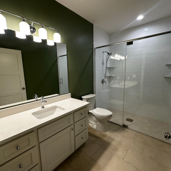 Contemporary bathroom with glass-enclosed shower and green accent wall