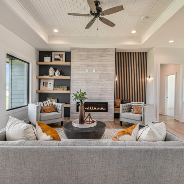 A cozy living room featuring a sleek modern fireplace, built-in shelving, and stylish furniture.