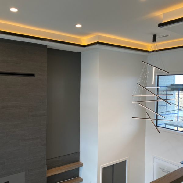 Metal railings and modern chandelier lighting in a custom-built home.